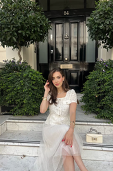 a lady in a solid white dress with hollow patterns and mesh